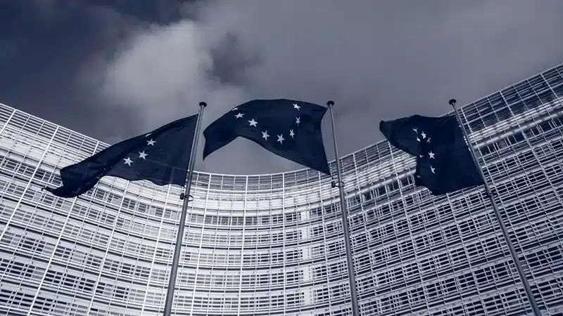 Drapeaux européens bleus avec étoiles flottant devant bâtiment administratif moderne