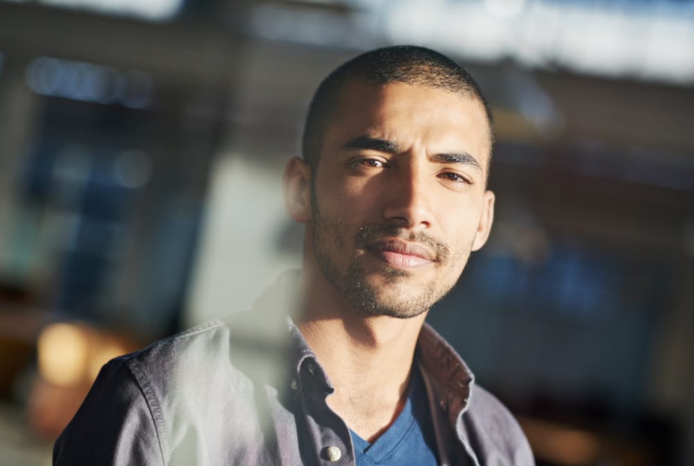 Jeune homme pris en photo au travers d'une vitre